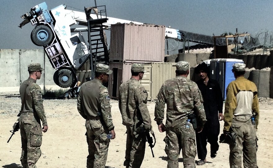 U.S. soldiers look at a crane that tipped over while trying to move a CHU, or Containerized Housing Unit, at a small COP, or Combat Outpost, in southern Afghanistan. A dozen years of war in Iraq and Afghanistan has created a whole new military vocabulary.