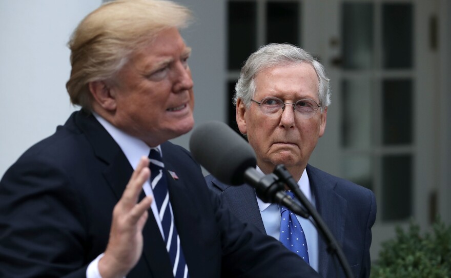 Senate Majority Leader Mitch McConnell looks on as Preisdent Trump speaks to reporters in the White House Rose Garden following a lunch meeting.