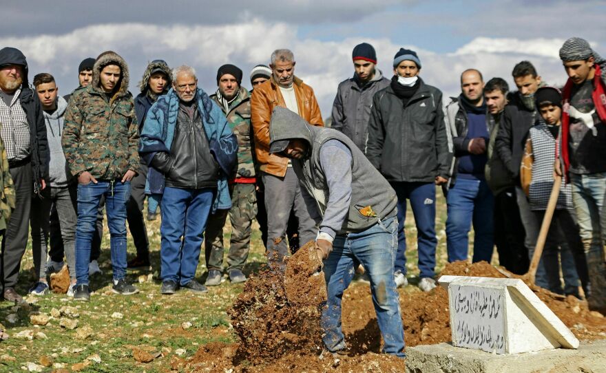People dig a grave for an earthquake victim in Aleppo, Syria on Tuesday.