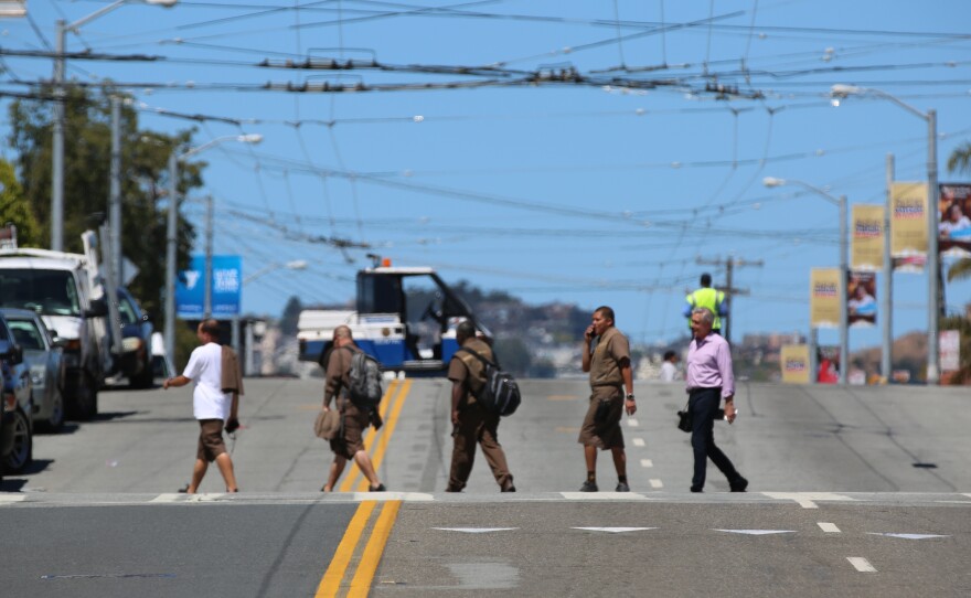 UPS employees cross the street shortly after a shooting at the company's facility in San Francisco. According to law enforcement, the suspect killed himself with a gunshot to the head.