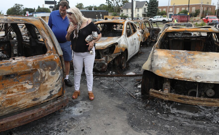 People survey the damage at a used car lot in Kenosha, Wisconsin.