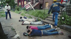In this photo, released July 17, 1989, a U.S. marshal keeps his pistol trained on suspects as other marshals raid a crack house in Washington, D.C. The city's crack epidemic lasted from the late '80s to the early '90s.