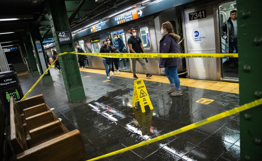 A flooded floor is blocked off in the 42nd Street Times Square subway station during a rain storm in New York, U.S., on Tuesday, Oct. 26, 2021. New York City commuters face a blustery, soaked-to-the-skin trek to work Tuesday as a powerful coastal storm unwinds across the Northeast.