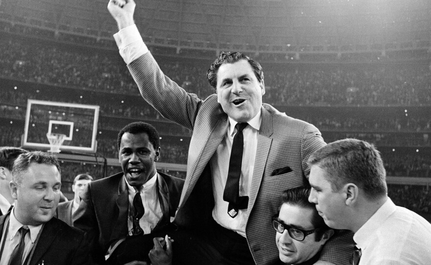 Guy V. Lewis, University of Houston basketball coach, is carried to the dressing room by happy fans after the Cougars' upset win over UCLA in an NCAA college basketball game at the Astrodome on Jan. 20, 1968. The game was known as college basketball's "Game of the Century."