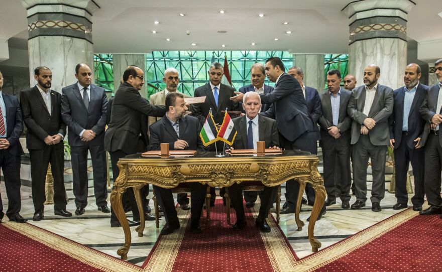 Senior Hamas leader Saleh al-Arouri (left) sits next to Fatah's Azzam al-Ahmad as they sign a reconciliation deal in Cairo on Thursday. Under the agreement, Hamas would cede control of the Gaza Strip to the Fatah-led Palestinian Authority by Dec. 1.
