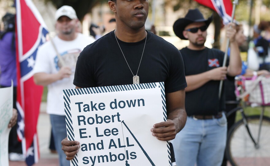 People demonstrate for and against the Confederate monuments in front of City Hall this month.