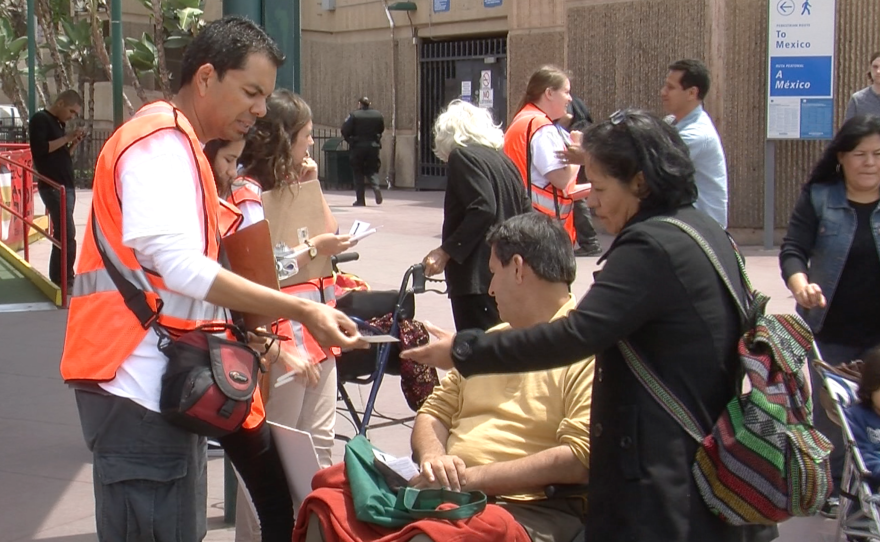 Immigration activists give people crossing the border informative pamphlets about their rights, May 13, 2015. 