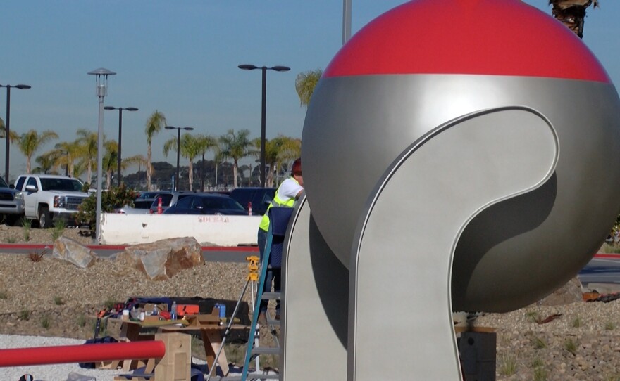 A worker fine tunes the bottom of artist Christian Moeller's sculptures at the San Diego International Airport Rental Car Center, Dec. 9, 2015.