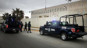 Federal police patrol outside the U.S. Consulate in Ciudad Juarez, Mexico, on Monday. U.S. and Mexican officials say they're looking into why a suspected drug gang ambushed two cars carrying families with ties to the U.S. consulate.