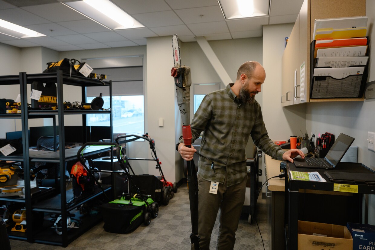 Alex Neu, an eResources and systems librarian with the National City Public Library in National City, California, checks back in a recently-returned pole saw on October 13, 2025. Neu runs u-Tool-ize, the library's new tool lending program.