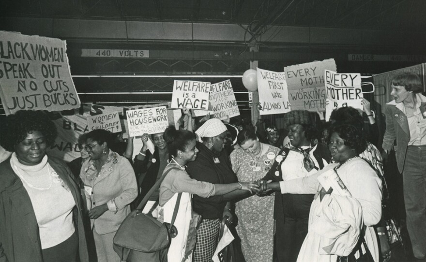 
Welfare rights leaders (including Johnnie Tillmon and Beulah Sanders) put their hands together, celebrating passage of their National Plan of Action item at the First National Women's Conference in Houston, Texas.