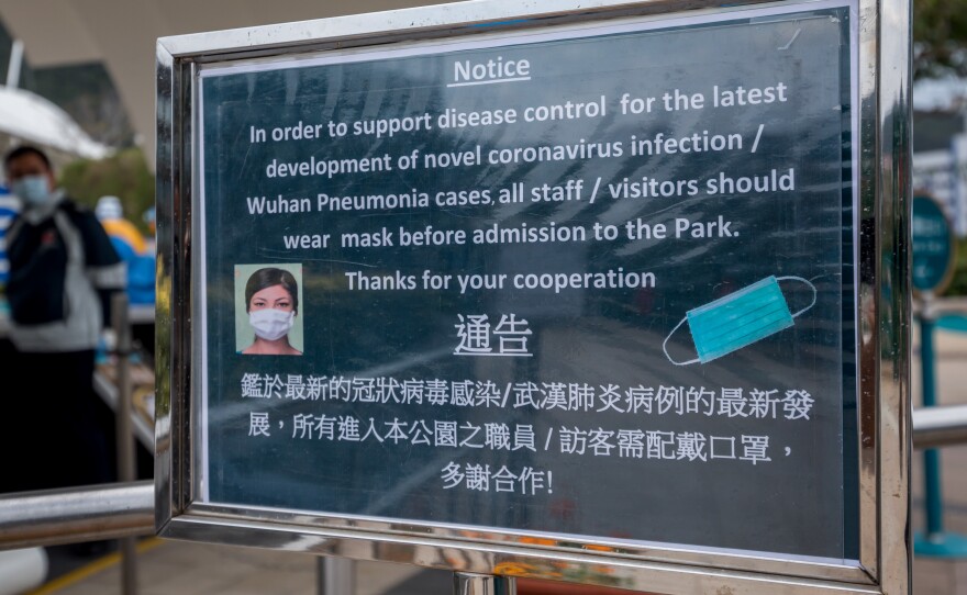 A notice advising all staff and visitors to wear protective masks stands outside the closed Ocean Park in Hong Kong, on Monday.