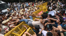 Supporters of the Cockroach Janta Party scuffle with police as they attempt to march to India's Parliament, demanding the resignation of the education minister, in New Delhi, Monday.