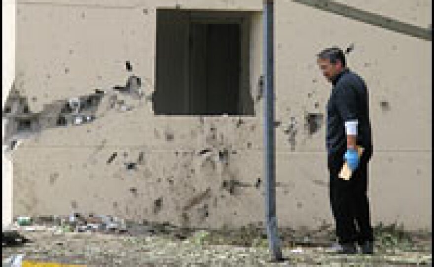 A U.S. investigator combs through the rubble outside the walls of the U.S. Embassy in San'a.