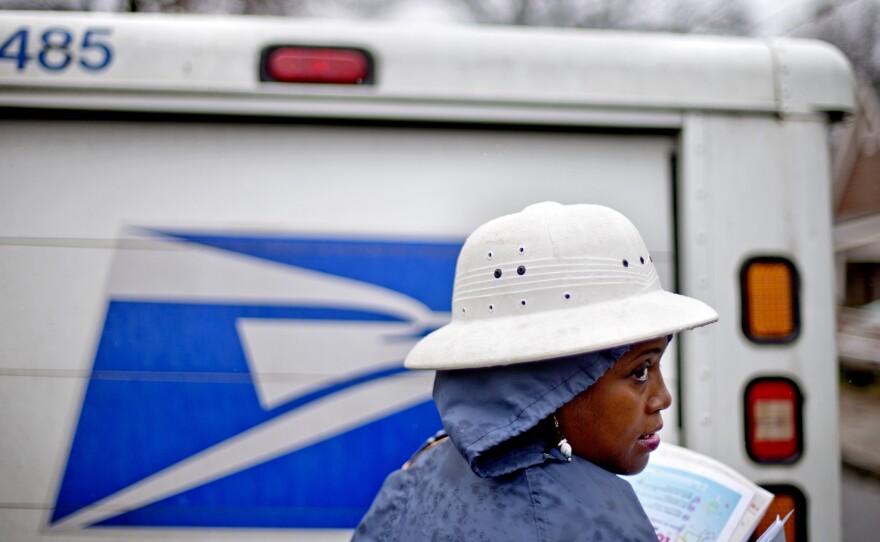 U.S. Postal Service letter carrier Jamesa Euler delivers mail in the rain in Atlanta in February.