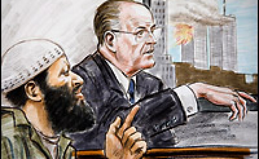 Zacarias Moussaoui (L) listens to former New York Mayor Rudolph Giuliani testify while a video of the Sept. 11 attacks plays in the background Thursday at the Federal Court in Alexandria, Va.