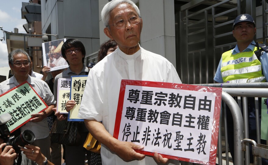 Hong Kong's outspoken cardinal Joseph Zen, center, and other religious protesters hold placards with "Respects religious freedom" written on them during a demonstration outside the China Liaison Office in Hong Kong, Wednesday, July 11, 2012.