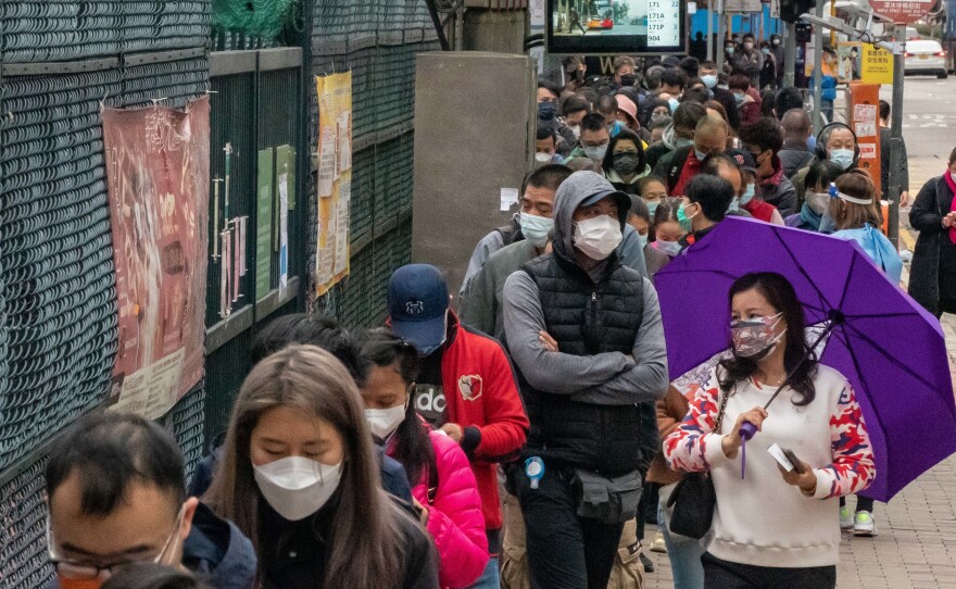 Residents wait in line at a makeshift COVID-19 testing station on Feb. 18 in Hong Kong. The Hong Kong government is rolling out city-wide COVID-19 testing with support from mainland authorities.