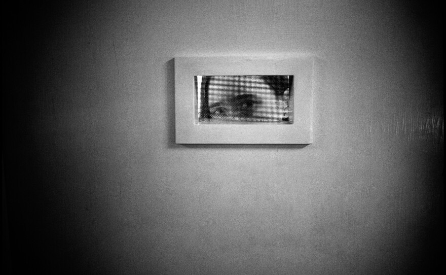 Tommie peeking out of her room, Ward 81, Oregon State Hospital. Salem, Oregon, 1976.