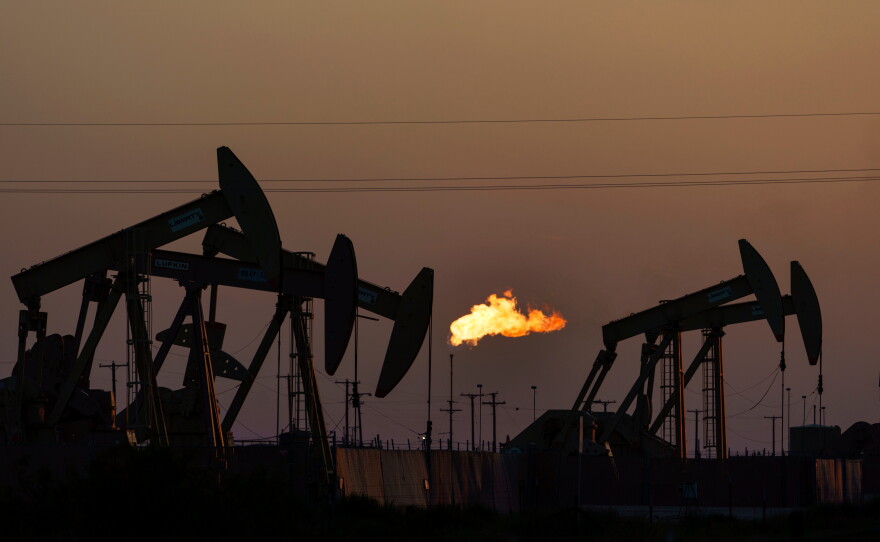 FILE - A flare burns off methane and other hydrocarbons as oil pumpjacks operate in the Permian Basin in Midland, Texas, on Oct. 12, 2021. (AP Photo/David Goldman, File)