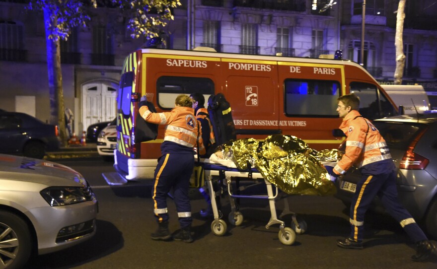 Rescue workers evacuate an injured person on Boulevard des Filles du Calvaire, near the Bataclan.