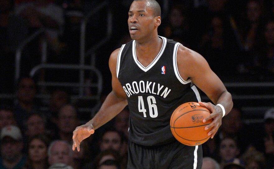 Brooklyn Nets center Jason Collins dribbles the ball during the second half of an NBA basketball game against the Los Angeles Lakers, Feb. 23, 2014, in Los Angeles.