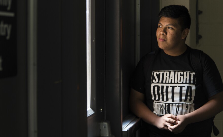 Jose Arriaga waits for his friends under the stairs at the end of the school day at Booker T. Washington High School. Jose began his freshman year this semester.