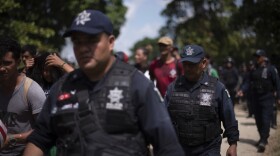 Mexican Federal Police escort a new group of Central American migrants who waded in mass across the Suchiate River, that connects Guatemala and Mexico, in Ciudad Hildalgo, Monday, Oct. 29, 2018.
