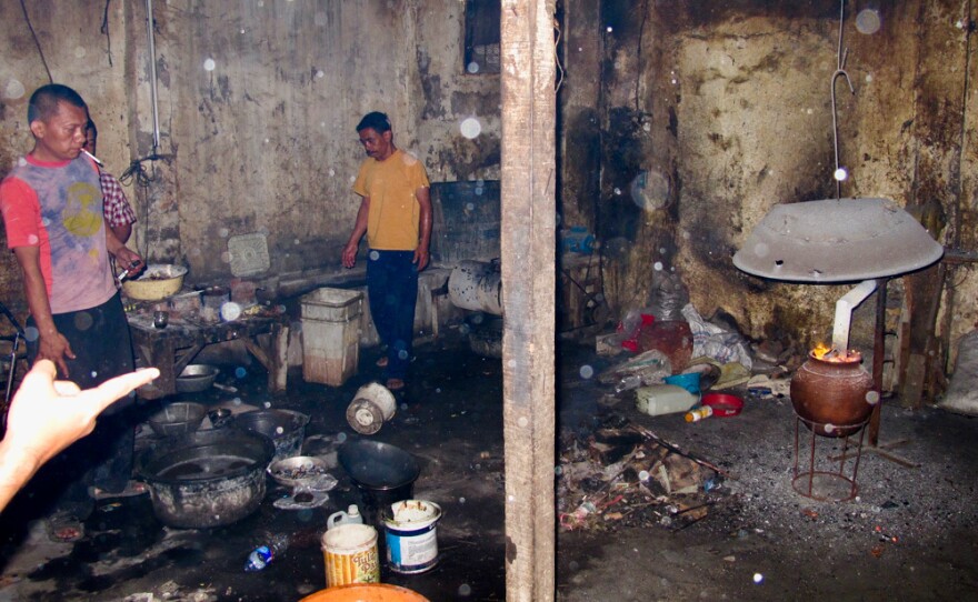 At a "backyard" recycling operation just outside of Jakarta, men place circuit boards in an oven and fire them to smelt out gold and other precious metals.