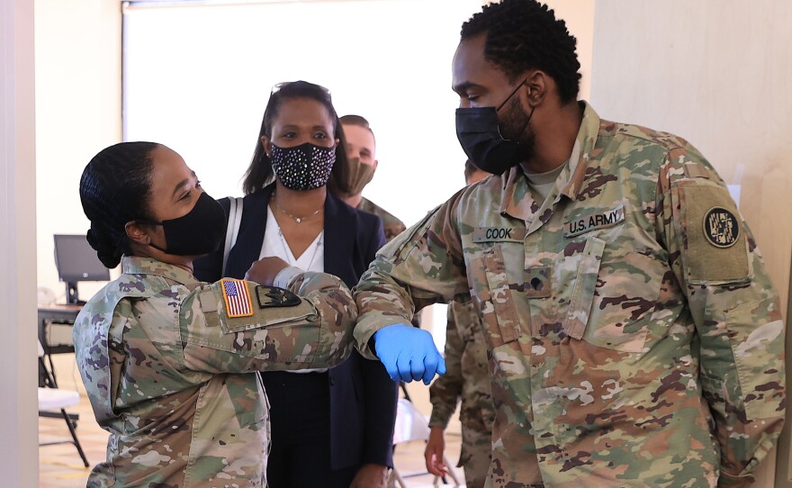Nearly 130 million U.S. adults have completed their vaccine regimens, the CDC says, with another 70 million vaccine doses currently in the distribution pipeline. Here, Maryland National Guard Brig. Gene. Janeen Birckhead greets soldiers at a mobile vaccine clinic in Wheaton, Md.