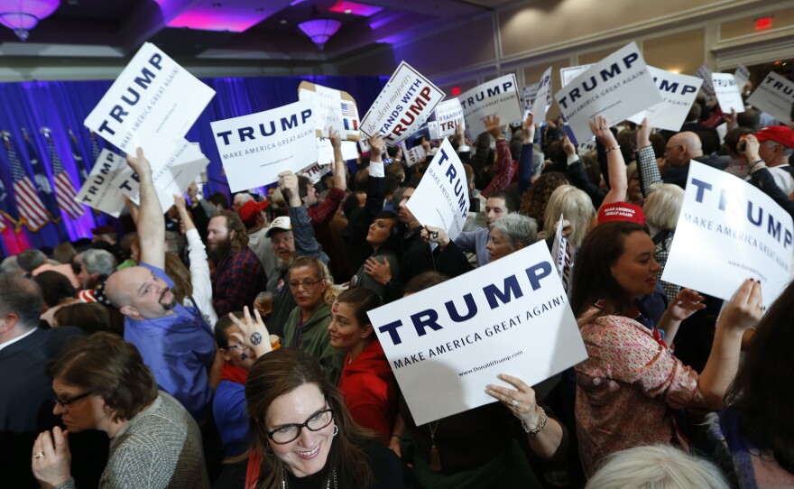 Supporters for Republican presidential candidate Donald Trump hold signs during a South Carolina Republican primary night event in Spartanburg, S.C.