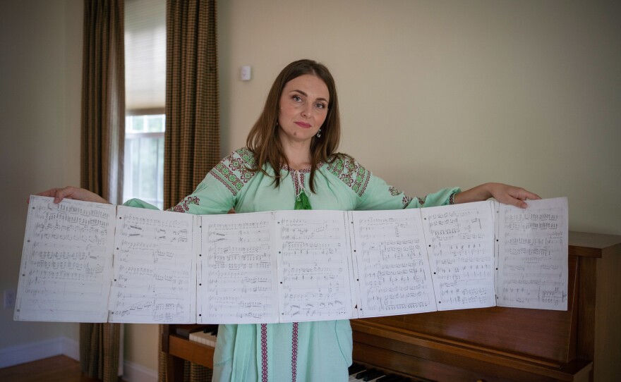 Olha Abakumova unfurls some of her Ukrainian sheet music. She was able to find a piano — free on Facebook — for her new home in a Boston suburb, where she practices her Ukrainian arias.