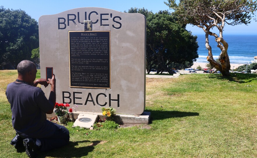 William Redmond III, a visitor from Atlanta, takes a photo of the historic plaque marking Bruce's Beach in April in Manhattan Beach, Calif.