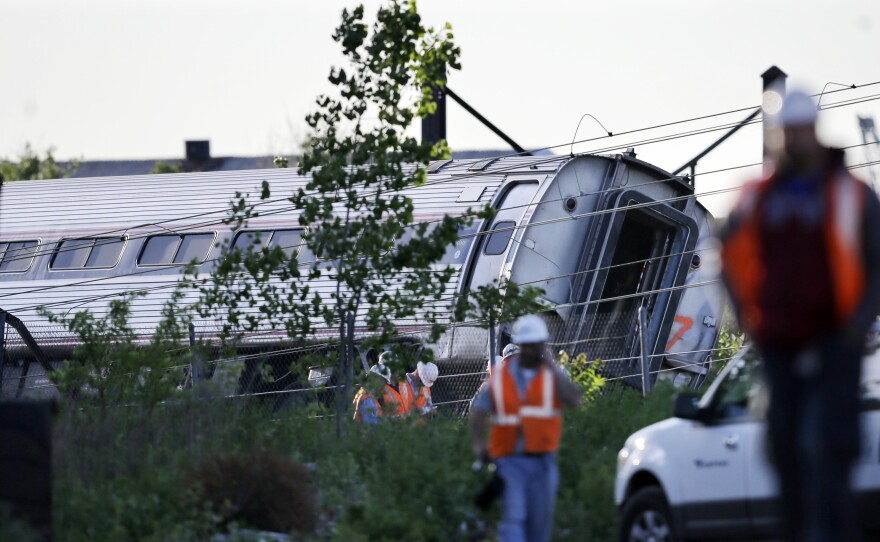 Emergency personnel walk near the scene of a deadly train wreck on Wednesday in Philadelphia.