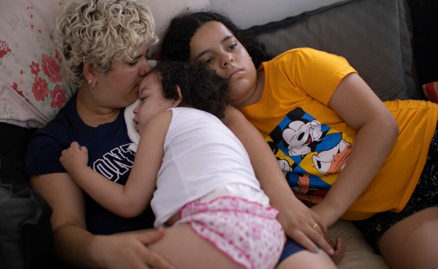 Dos Santos, left, with her daughters. Dos Santos says she feels used and that many other families share the same sentiment. Medical anthropologist Luciana Lira says the families became overwhelmed by scientists and journalists, and that she had to change her approach to gain the families' trust.