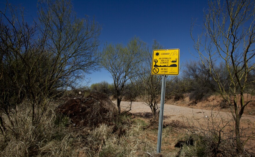 A sign warns against the many dangers in the desert in Spanish, saying, "It's not worth it."