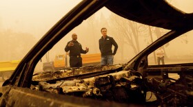California Gov. Gavin Newsom examines a scorched car while visiting Greenville, which suffered extensive structure loss during the Dixie Fire, on Saturday, Aug. 7, 2021, in Plumas County, Calif. Accompanying him is Cal Fire Assistant Region Chief Curtis Brown. 