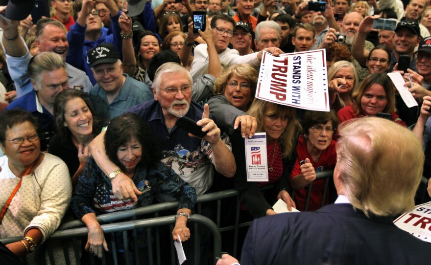 Donald Trump stops as supporters reach out for him to sign autographs during an October rally in Nevada.