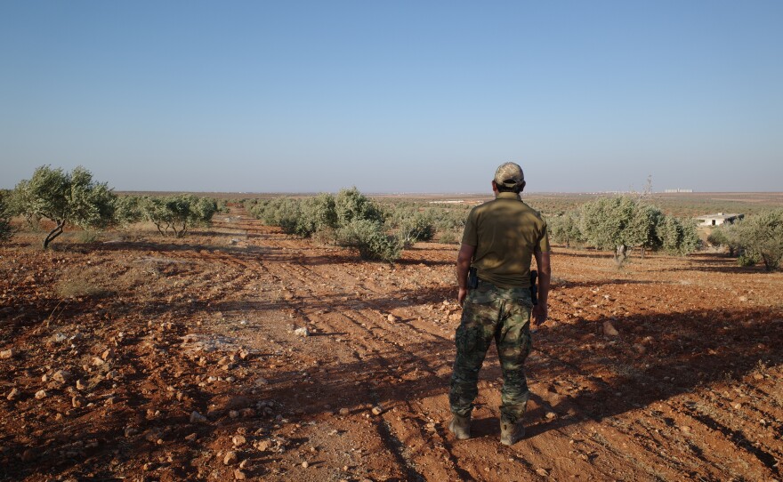 A senior Uyghur militant stands in an olive grove in northern Syria, where Uyghur commanders say their fighters began an ultimately successful assault on Syrian regime forces in November 2024.