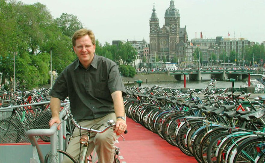 Rick Steves atop the bike garage in Amsterdam. The Basilica of St. Nicholas is in the background.