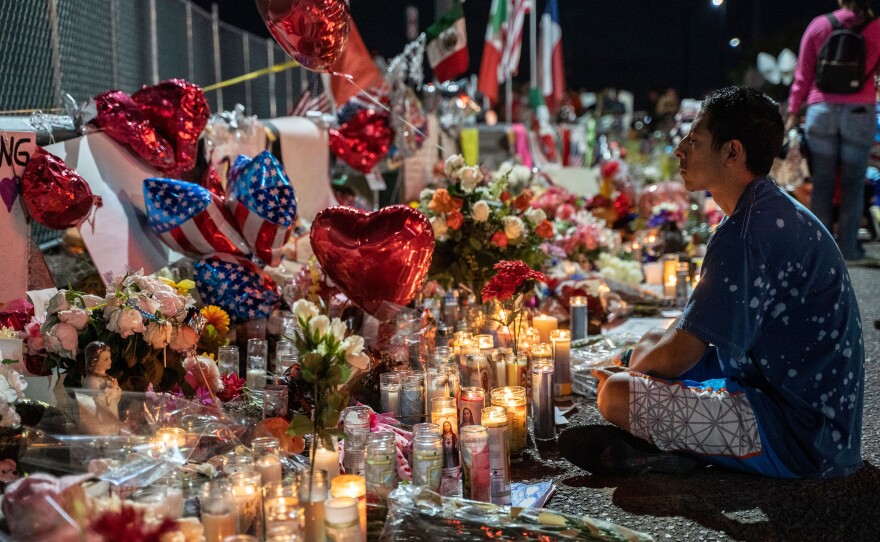 Abel Valenzuela, local of El Paso, meditates in front of the makeshift memorial for shooting victims at the Cielo Vista Mall Walmart in El Paso, Texas, on August 8, 2019.
