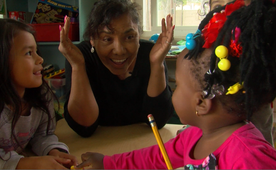 Gloria Smith sings, "Head, shoulders, knees and toes," with two girls in her La Mesa childcare center, Jan. 19, 2017.