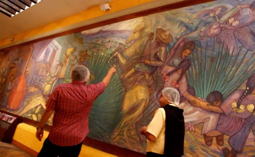 Host Jorge Meraz views an art mural while learning about the Tequila-making process at the Jose Cuervo factory. Tequila, Jalisco in Mexico.