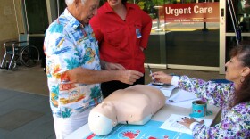 Scripps professional development specialist Abigail Alexander and nurse Joanne Benintende give local resident Fred Di Carlo a quick lesson in how to perform CPR outside Scripps Clinic in Rancho Bernardo.