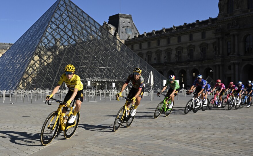 The pack with Denmark's Jonas Vingegaard, wearing the overall leader's yellow jersey, passes the Louvre Museum during the 21st stage of the men's Tour de France cycling race.