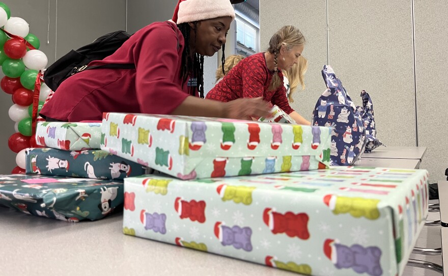 Adults help prepare donated gifts for Chollas-Mead Elementary School students, Dec. 17, 2025.