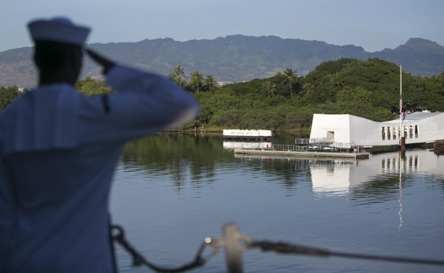 A Navy sailor salutes the memorial to the USS Arizona on Dec. 7, the 75th anniversary of the Japanese attack on Pearl Harbor. The Arizona was hit in the air raid.