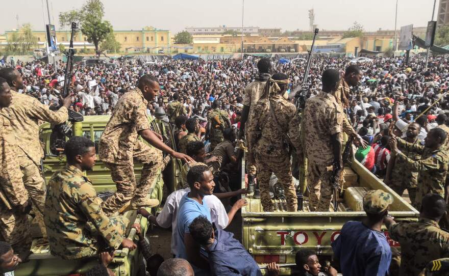 Sudanese soldiers stand guard on armored vehicles as demonstrators protest against President Omar al-Bashir's regime near the army headquarters in the Sudanese capital Khartoum Thursday.