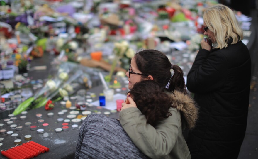 People weep as they gather Monday at the Place de la Republique to observe a minute of silence in memory of the victims of the Paris terror attacks.