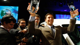 Ford Motor Co. President of the Americas Mark Fields holds up the 2010 North American Truck of the Year award and Car of the Year award Monday at the North American International Auto Show in Detroit.